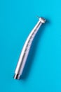 Top view shot of a dental high-speed handpiece on the blue background