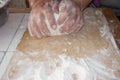 Top view shot of female hands mixing dough. Female hands knead dough on wooden board. Royalty Free Stock Photo