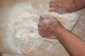 Top view shot of female hands mixing dough. Female hands knead dough on wooden board. Royalty Free Stock Photo