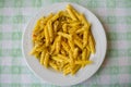 Top view shot of a gourmet dish of cheesy penne pasta on a kitchen towel