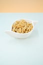 Top view shot of italian pasta in a canister on a light blue surface Royalty Free Stock Photo