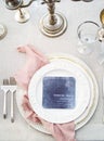 Top view shot of luxury forks and a ceramic plate with wedding menu paper on gray table