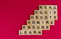 Top view shot of must have values written with wooden blocks on pink background