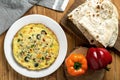 Top view shot of an omelette with mushrooms and colorful peppers and lavash next to it