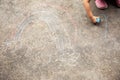 Top view shot of preschool child girl whos is drawing colorful rainbow on pavement or concrete floor in the park by the color Royalty Free Stock Photo