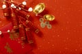 Top view shot of red gift envelopes, firecrackers, gold ingots, and copper coins