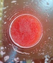 A top view shot of red watermelon juice taken from the edge of the glass