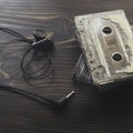 Top view shot of retro tape cassette with earphone on wood tab Royalty Free Stock Photo