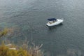 Top view shot of a white boat with people in and next to it close to a beach