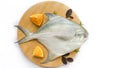 Top view of Silver Pomfret,White Pomfret fish dish cooking with various ingredients. Fresh raw fish decorated on a wooden pad, Royalty Free Stock Photo