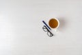 a top view of a simple desk office table desk workplace with hot cup of tea, pen and glasses, copy space Royalty Free Stock Photo