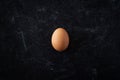 Top view of simple organic brown egg on dark moody background. Royalty Free Stock Photo