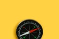 Top view single black compass isolated on yellow background