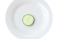 Top view of single fresh cucumber slice on white plate isolated on white background Royalty Free Stock Photo