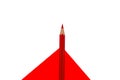 Top view of single wood pencil crayon of red color placed on top of a red white background