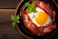 Top view of sizzling bacon and perfectly fried egg in a pan delicious breakfast concept