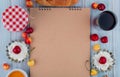 top view of sketchbook and cottage cheese with fresh ripe yellow and red cherries glass of juice arranged around on grey