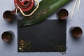 Top view of slate mat, tea cups, pot, green dried tea.Traitional chinese tea ceremony.Empty space for text Royalty Free Stock Photo