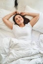 Pleased cute lady reposing in her bedroom