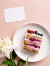 top view of slice blueberry cake, peony flower and blank card