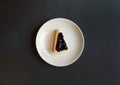 Top view of slice of blueberry cheesecake in white dish or plate with copy space. Flat lay of sweet snack