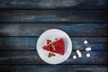 Top View. Slice of delicious Red velvet cake on a white plate with rafinated sugar on a colored wooden background Royalty Free Stock Photo