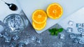 top view of slice fresh orange on cutting board near leaf, ice, glass Royalty Free Stock Photo