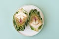 Top view Sliced artichoke on plate on green background. Healthy food vegetables.