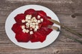 Top view on sliced baked beetroot appetizer salad with with fork and knife on wooden table. Royalty Free Stock Photo