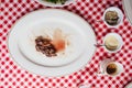 Top view of Sliced medium rare charcoal grilled wagyu Ribeye steak in white plate on red and white pattern tablecloth.