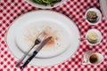 Top view of Sliced medium rare charcoal grilled wagyu Ribeye steak in white plate on red and white pattern tablecloth.