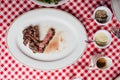 Top view of Sliced medium rare charcoal grilled wagyu Ribeye steak in white plate on red and white pattern tablecloth. Royalty Free Stock Photo