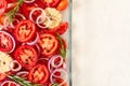 Top view of sliced tomatoes, garlic, onion and rosemary in a glass oven dish. Mediterranean food. With Copy space for test