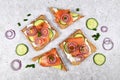 Top view of slices of healthy wholegrain toast bread topped with smoked salmon fish, red onions and spring onions and cucumber Royalty Free Stock Photo