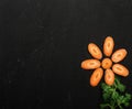 Top view of slices of sweet carrot in the shape of a flower with parsley, healthy food