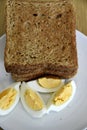 Top view of slices of toasted whole wheat bread with boiled eggs on a plate for breakfast Royalty Free Stock Photo