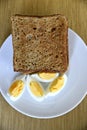 Top view of slices of toasted whole wheat bread with boiled eggs on a plate for breakfast Royalty Free Stock Photo