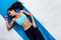 Top view of slim fitness model lying on mat resting after workout