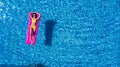 Top view of slim young woman in bikini on the air mattress in the big swimming pool. Enjoying sunmtan. Vacation concept Royalty Free Stock Photo