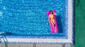 Top view of slim young woman in bikini on the air mattress in the big swimming pool. Enjoying sunmtan. Vacation concept Royalty Free Stock Photo