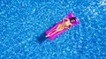 Top view of slim young woman in bikini on the air mattress in the big swimming pool. Enjoying sunmtan. Vacation concept Royalty Free Stock Photo