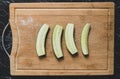 Top view on slised pieces of green cucumber on the board