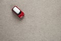 Top view of small bright red metal simple child toy car on light beige canvas cloth copy space background Royalty Free Stock Photo