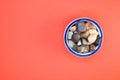 Top view of small colorful rocks in a china bowl on a peach-colored surface Royalty Free Stock Photo