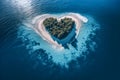 Top view of small exotic island with deep turquoise and emerald open ocean sea