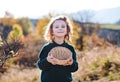 Small girl on a walk in nature, collecting rosehip fruit.