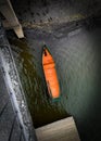 Top view of small lonely orange boat docked under the bridge Royalty Free Stock Photo