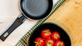 Top view of small pan and fresh ripe cherry tomatoes in small black bowl on a rustic white wooden table. Ingredients and food Royalty Free Stock Photo