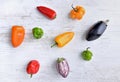 small peppers and eggplants on white table