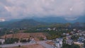 Top view of small resort town. Hotels, houses and roads. Green hills around. Rooftops. Panorama.